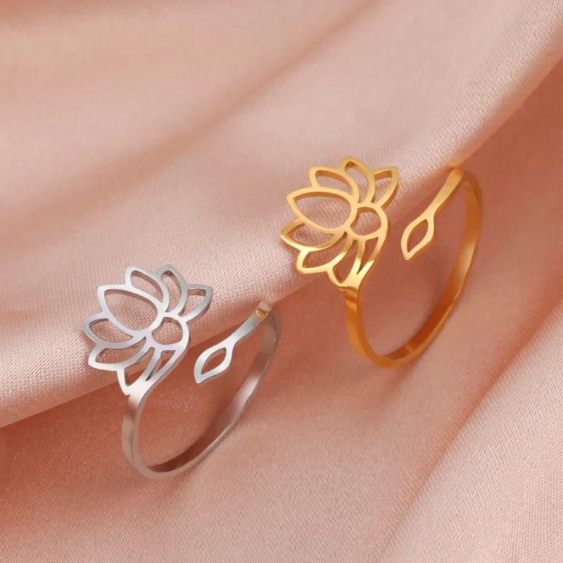 Bague Fleur de Lotus en argent posée sur un tissu rose, mettant en valeur son éclat délicat et son design ajouré.