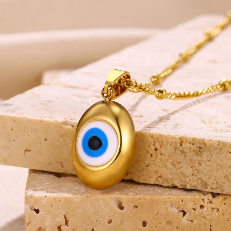 Collier Mauvais Oeil Or posé sur une pierre, bijou porte-bonheur protecteur