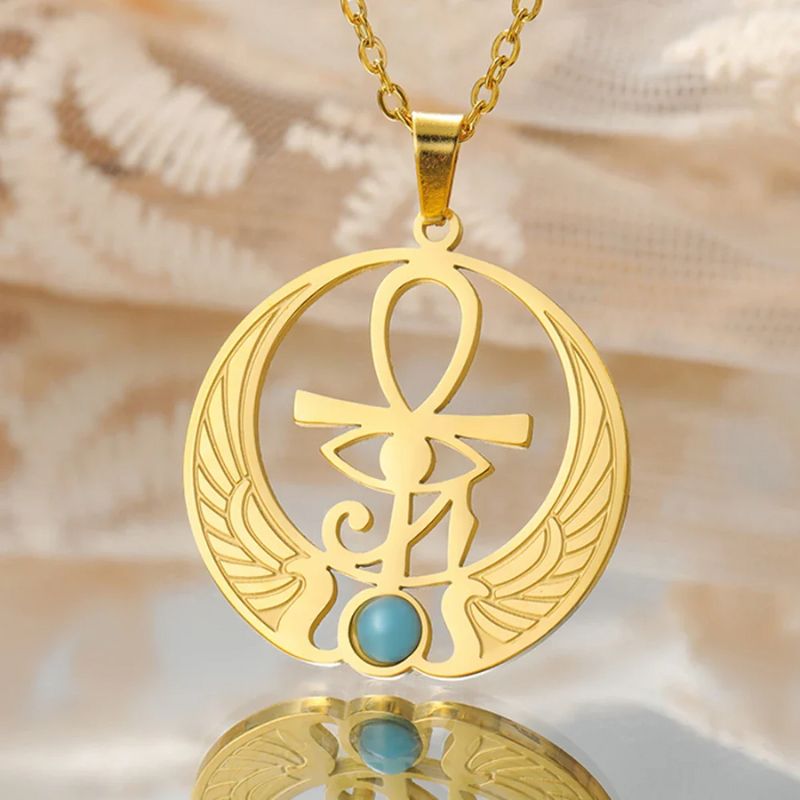 Collier Œil égyptien en acier inoxydable couleur or, suspendu à une chaîne délicate, mettant en avant son design raffiné avec ailes, Ankh et pierre bleue.